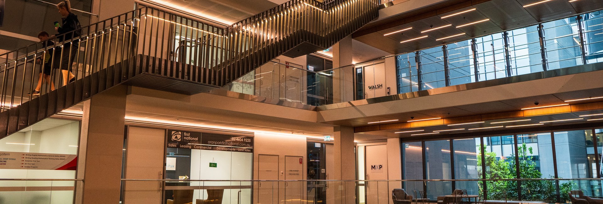 Illuminated multi-level building atrium at dusk